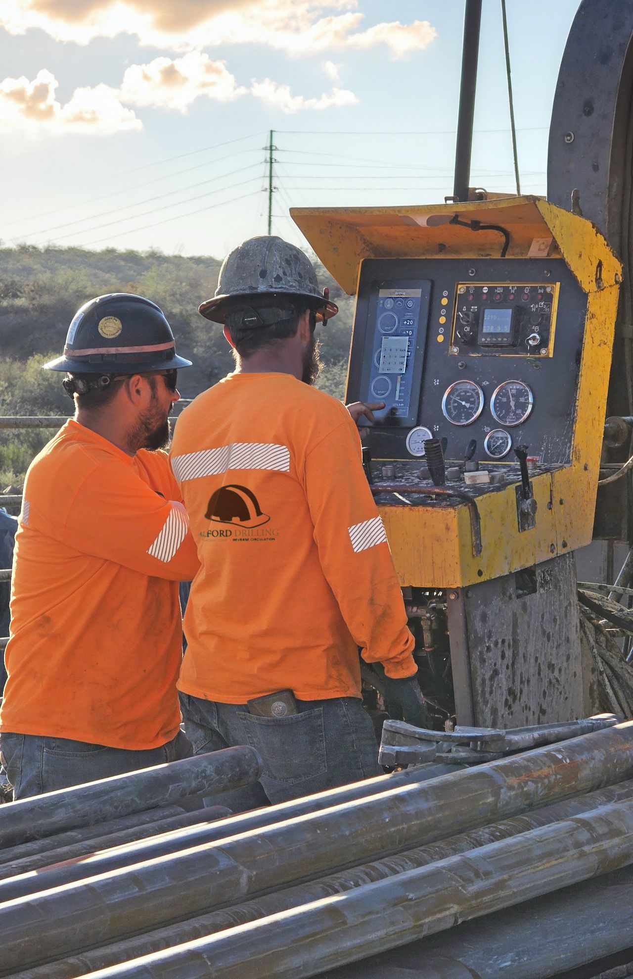 Drillers operating rig with Iron WatchDog console at sunset